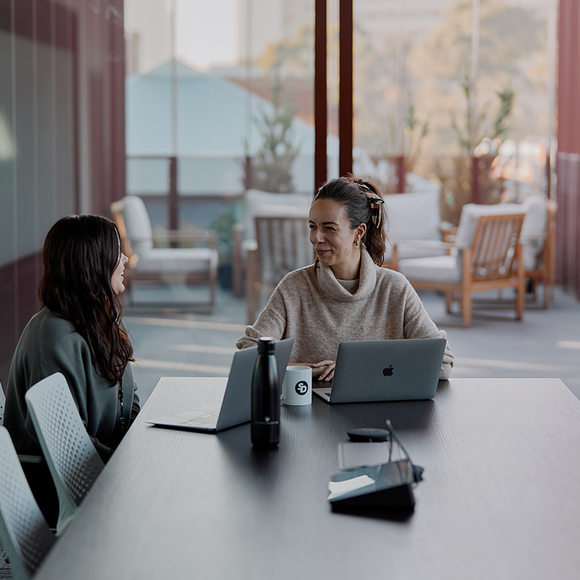 Two colleagues talking in a Sleeping Duck meeting room