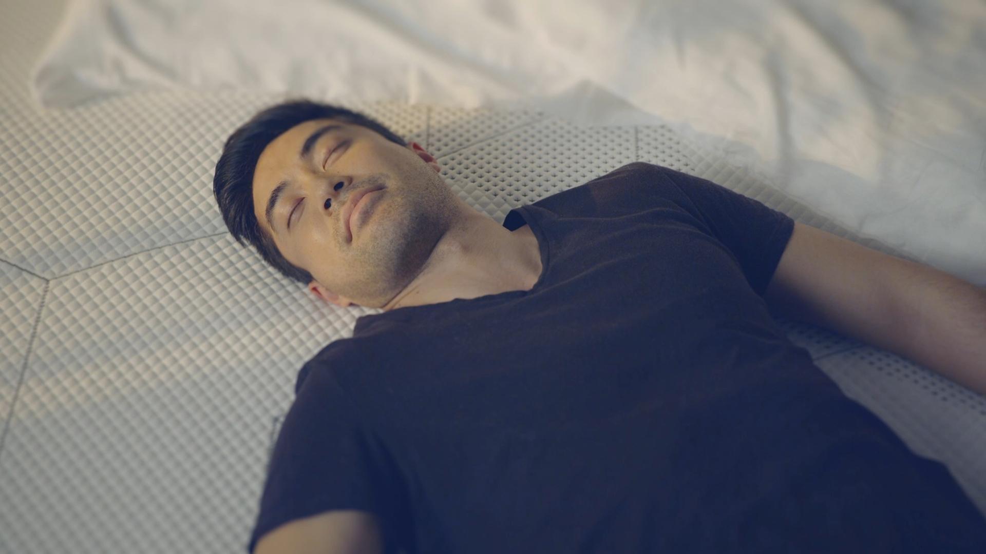 Man laying on top of a SD Mach 2 Mattress looking peaceful and comfortable.