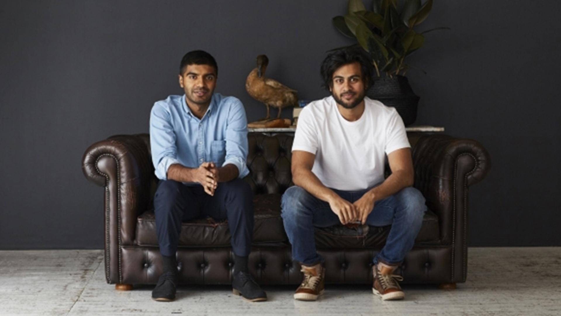 Founders of Sleeping Duck, Winston and Selvan, sitting on a leather couch with a smile.